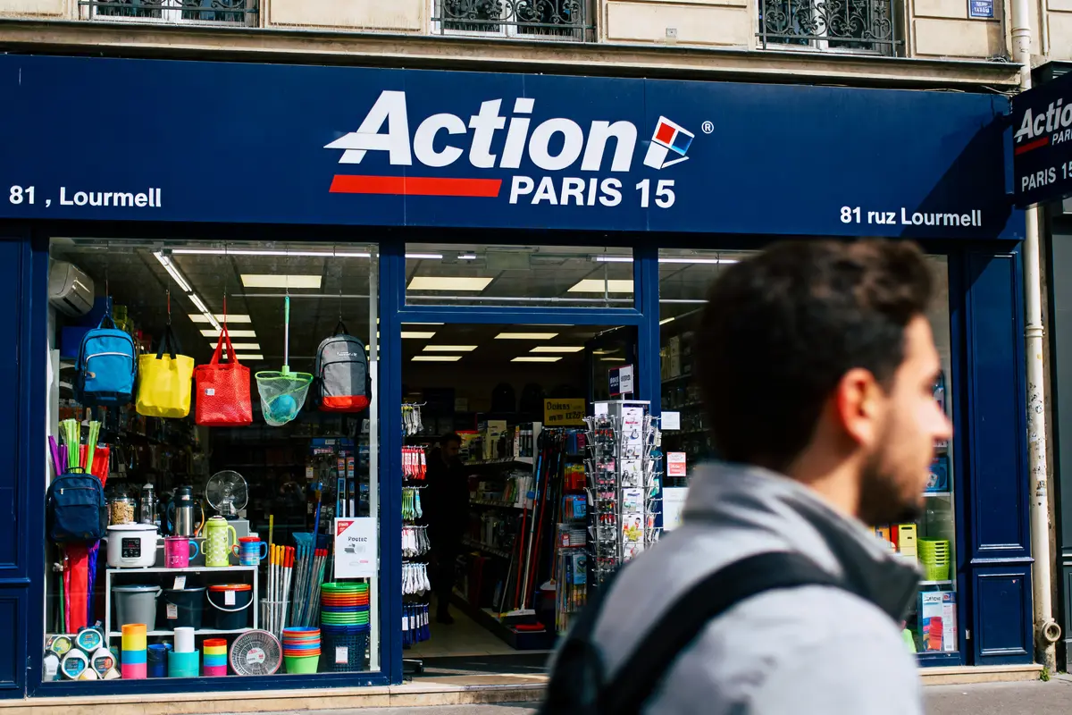 pexels-michal-pech-213601-757318 (1) Façade de magasin "Action" à Paris avec articles divers en vitrine et passant au premier plan.