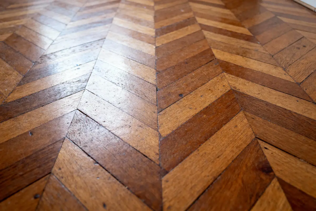 pexels-michal-pech-213601-757318 (1) Parquet en chevrons en bois clair et foncé, style géométrique, lames disposées en motif diagonal.