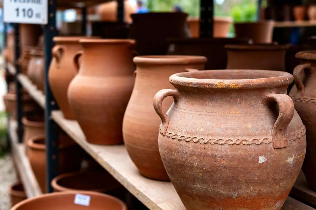 pexels-michal-pech-213601-757318 (1) Pots en terre cuite alignés sur étagères visibles dans une terrerie artisanale